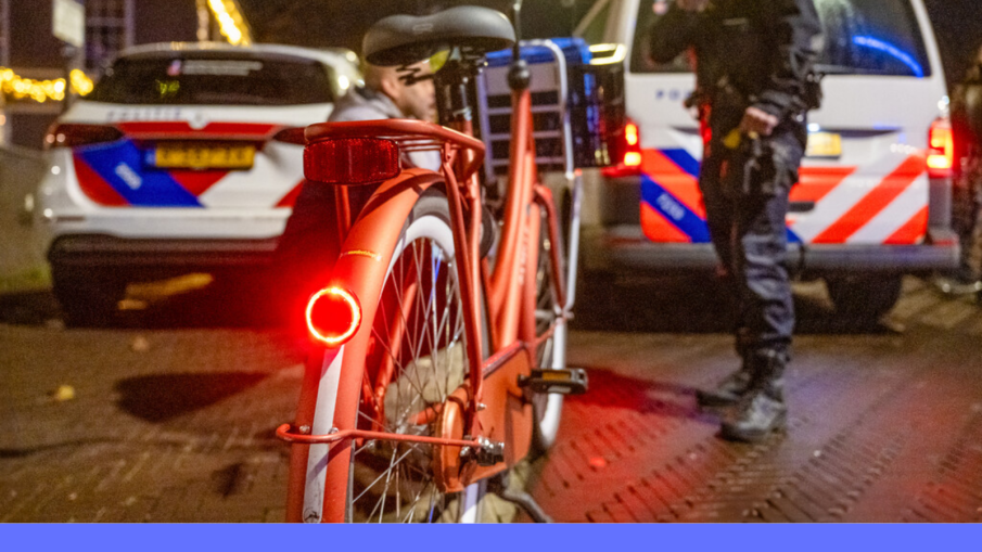 fiets met achterlicht politieauto's op achtergrond